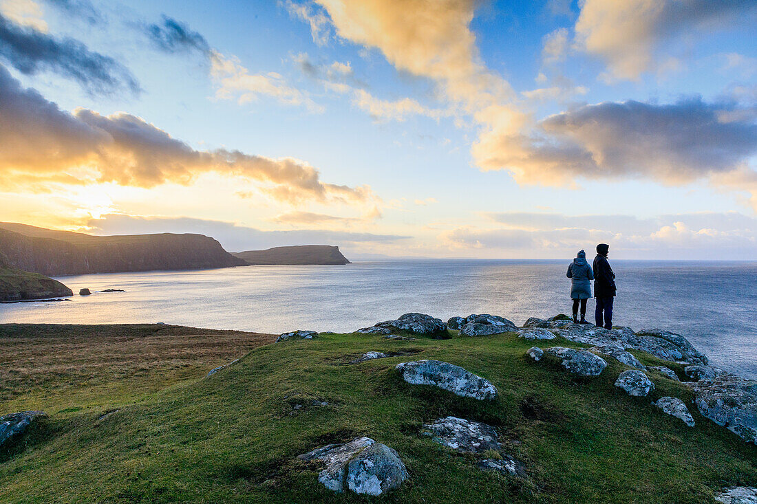 Touristen beim Sonnenaufgang am Neist Point, Isle of Skye, Schottland UK