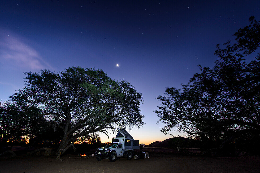 Camping around a campfire under a starry sky, Twyfelfontein, Namibia