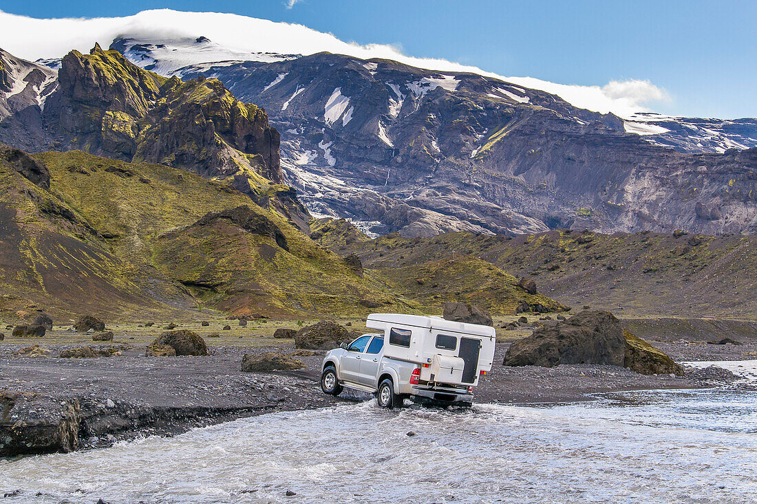 Campers fording a small river in the Icelandic highlands