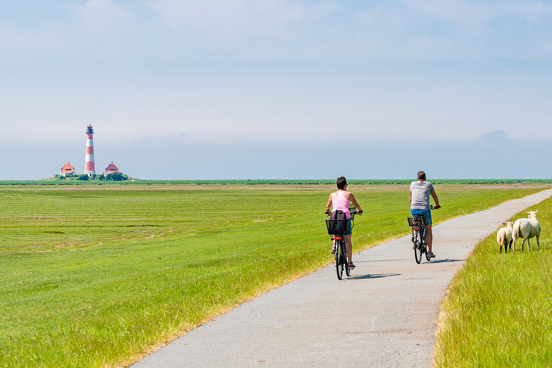 Cyclists, lighthouse, Westerhever, Schleswig-Holstein, Germany