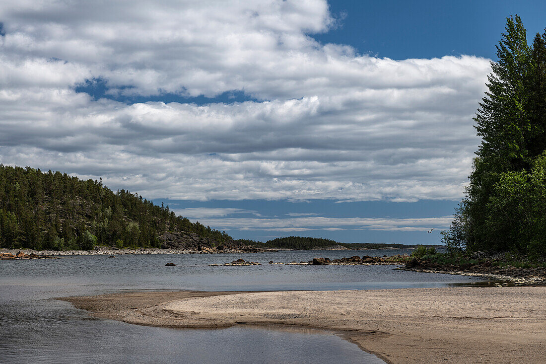 Eine kleine Bucht mit Strand an einem Sommertag am Meer, bei Avikebruk, Västernorrland, Schweden