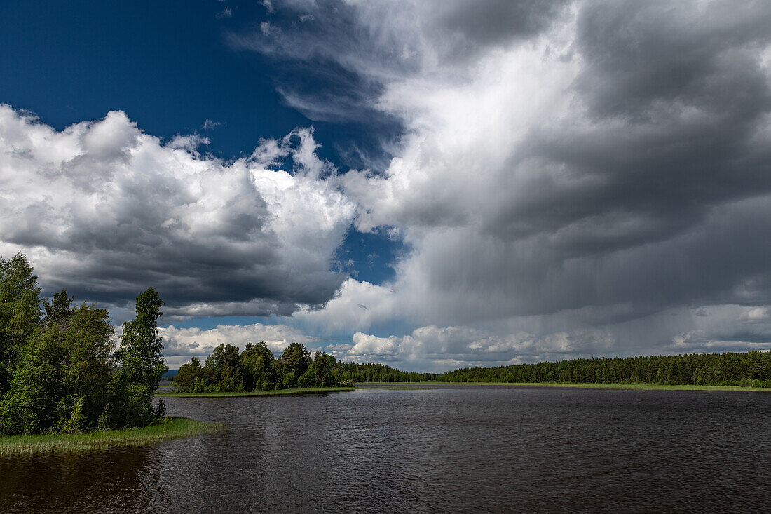 Regenschauer und dunkle Wolken über einem See bei Bramabo, Dalarna, Schweden