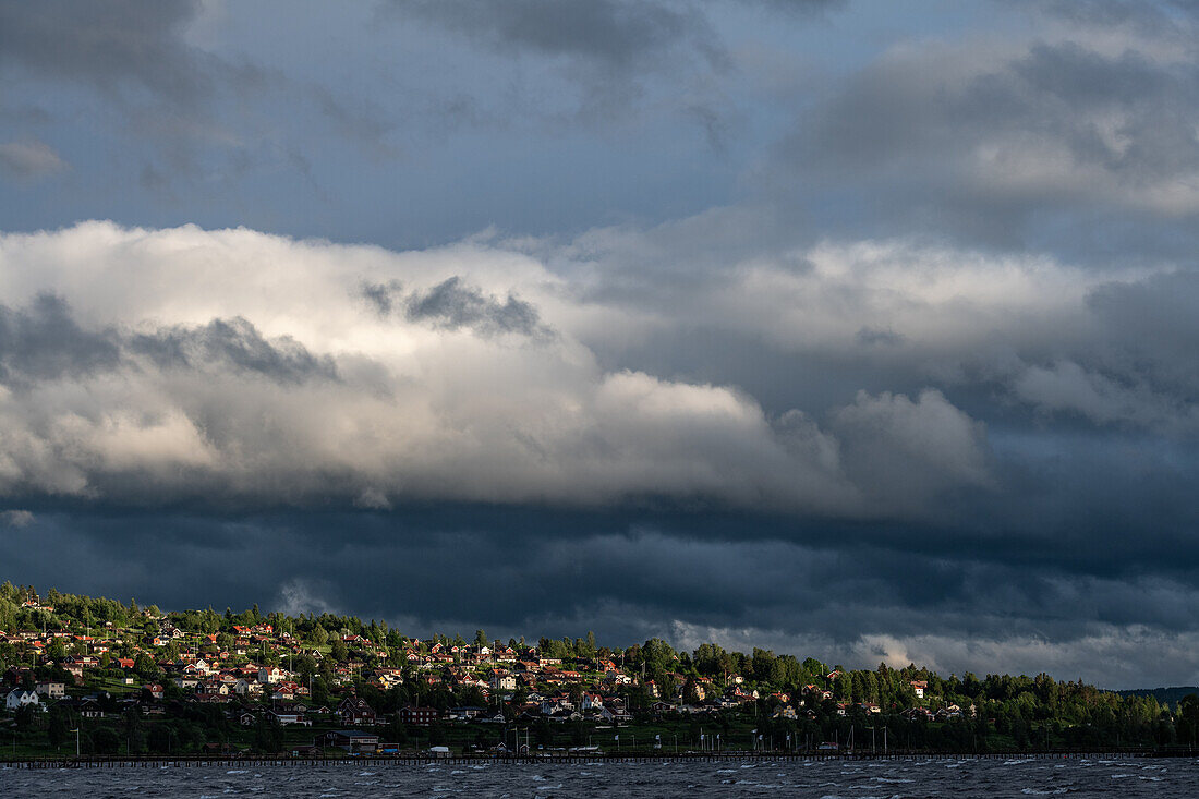 Dunkle Wolken über den Häusern am Ufer des Siljansees, Rättvik, Dalarna, Schweden