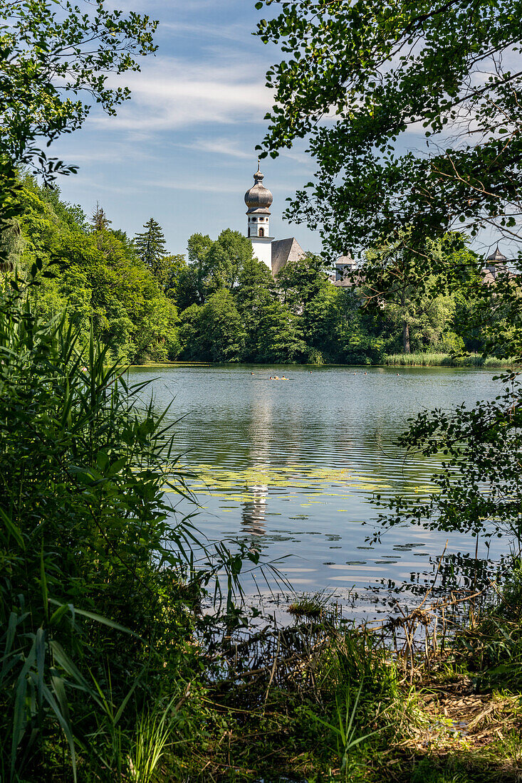 View in sunshine over the Höglwörther See to the monastery, Chiemgau, Bavaria, Germany