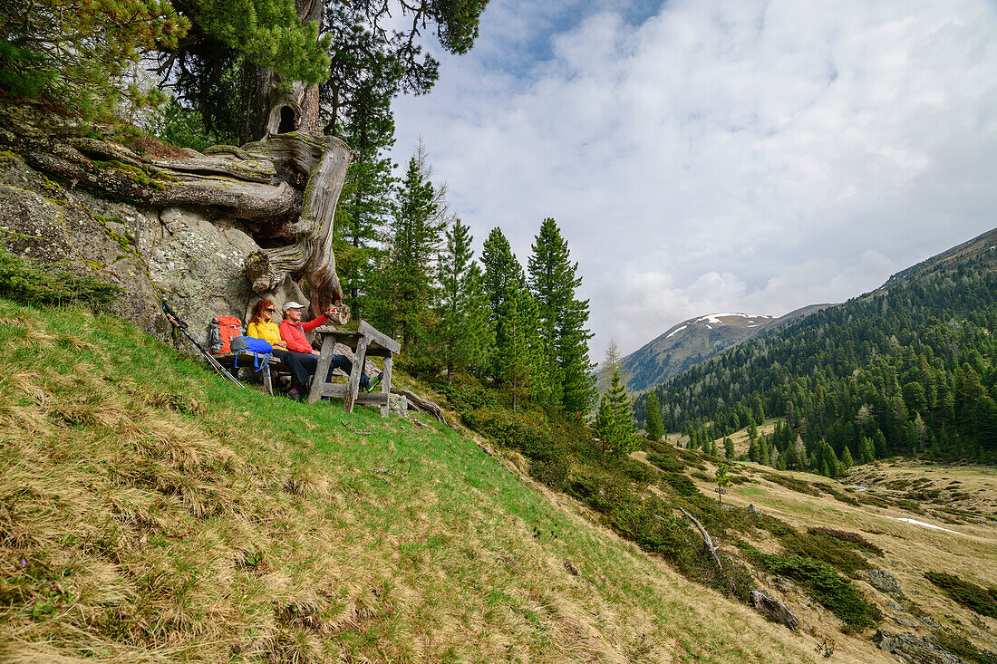 Man and woman while hiking take a break under rocks, Rosanintal, Königstuhl, Nockberge, Nockberge-Trail, UNESCO Biosphere Park Nockberge, Gurktal Alps, Carinthia, Austria