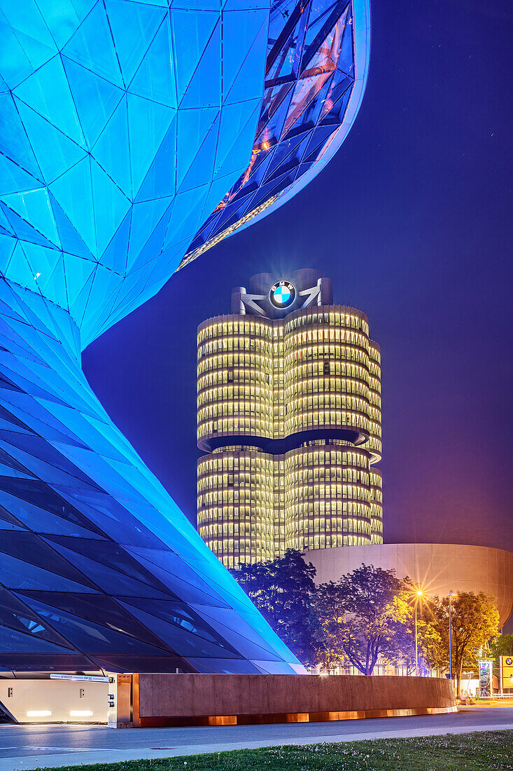 Blau beleuchtetes Gebäude der BMW Welt mit BMW Vierzylinder und BMW Museum im Hintergrund, München, Oberbayern, Bayern, Deutschland