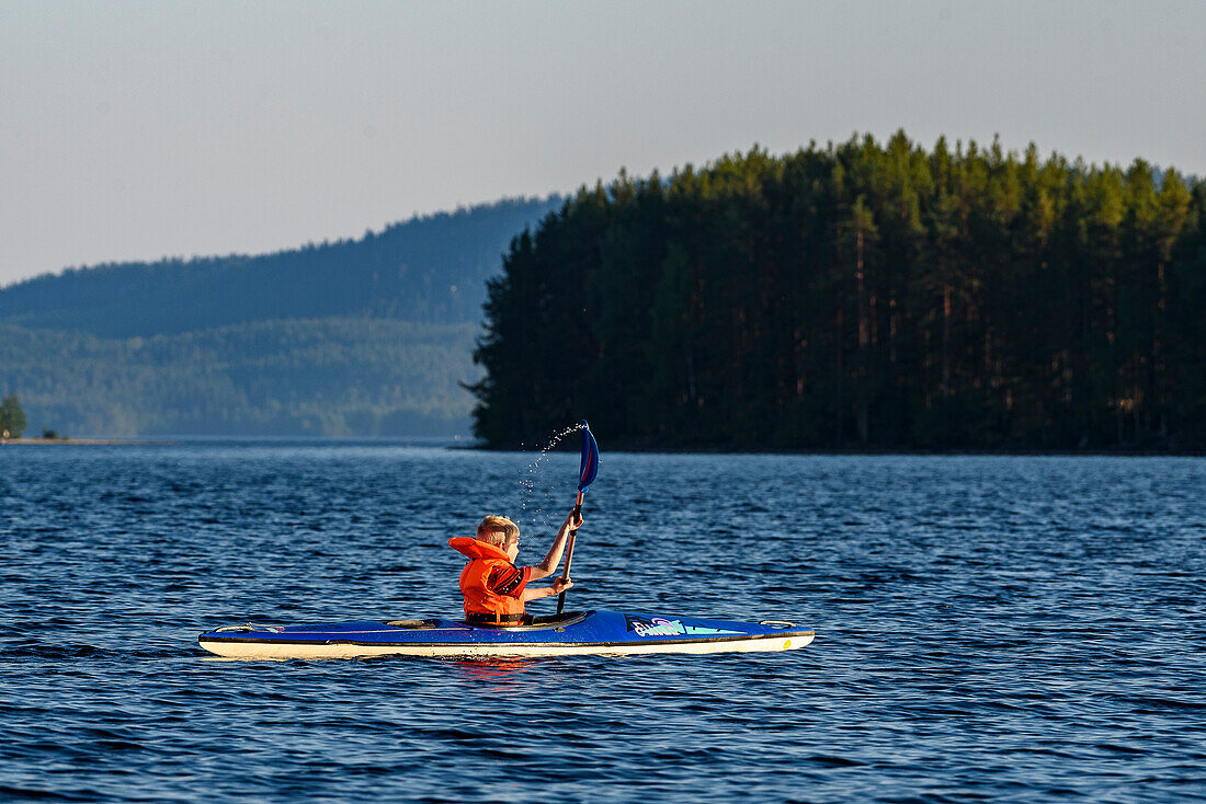 Kind paddelt am Pielinen-See, Finnland