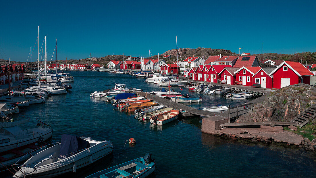 Rote Bootshäuser mit Booten auf der Schäreninsel Tjörn im Westen von Schweden\n