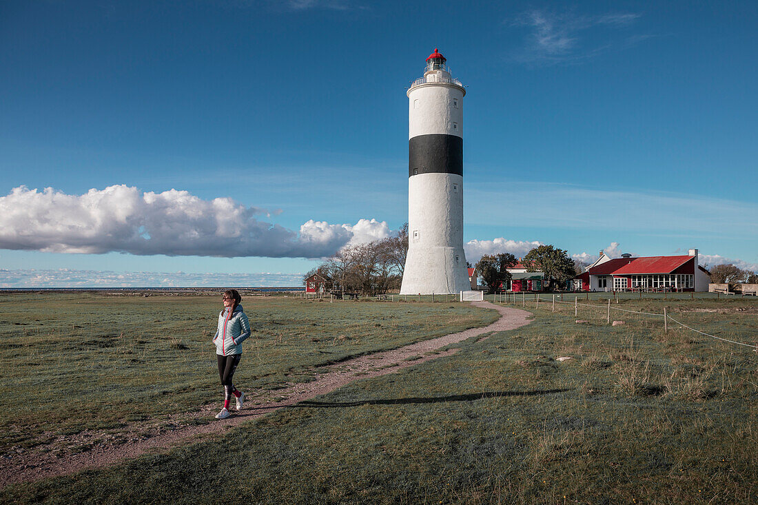 Frau am Leuchtturm Långe Jan im Süden der Insel Öland von Schweden bei blauem Himmel
