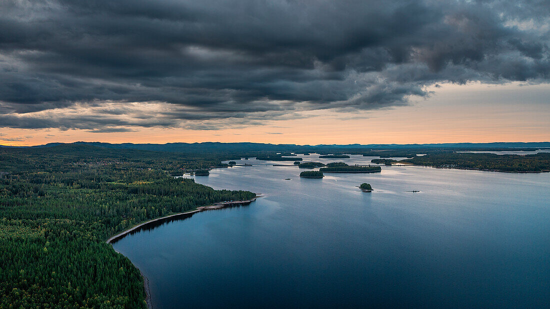Forest and lakeshore at Lake Siljan from above in sunset with clouds in Dalarna, Sweden