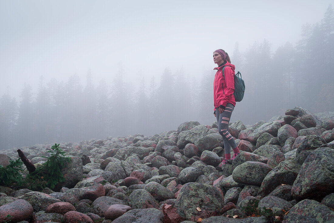 Frau wandert durch Steinfeld im Skuleskogen Nationalpark im Osten von Schweden