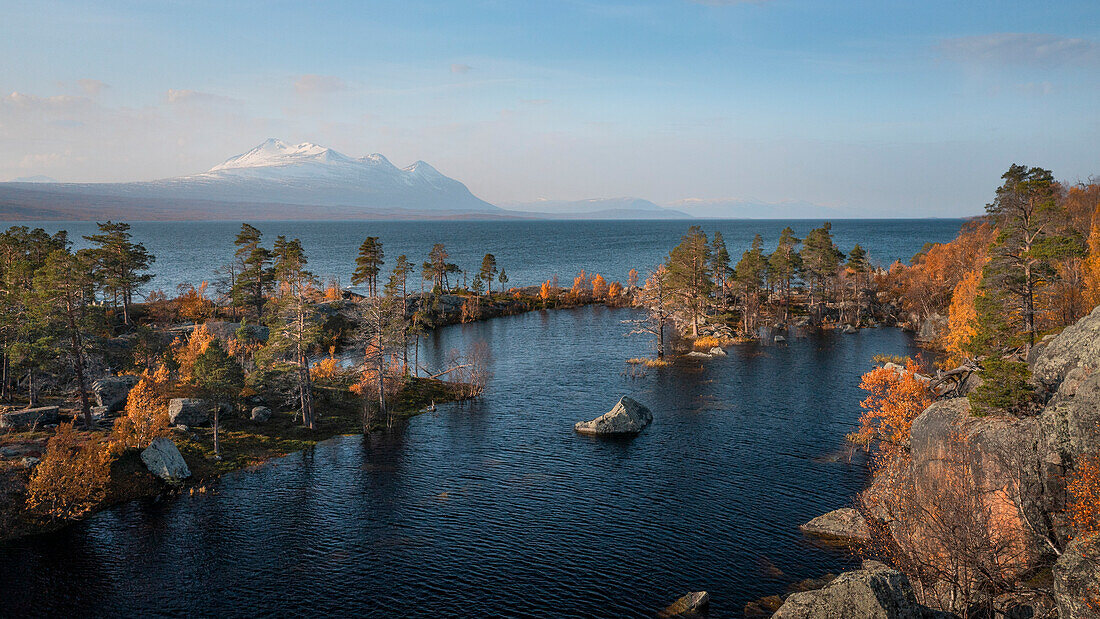 Landscape with snowy mountains of Sarek National Park and lake in Stora Sjöfallet National Park in autumn in Lapland in Sweden from above