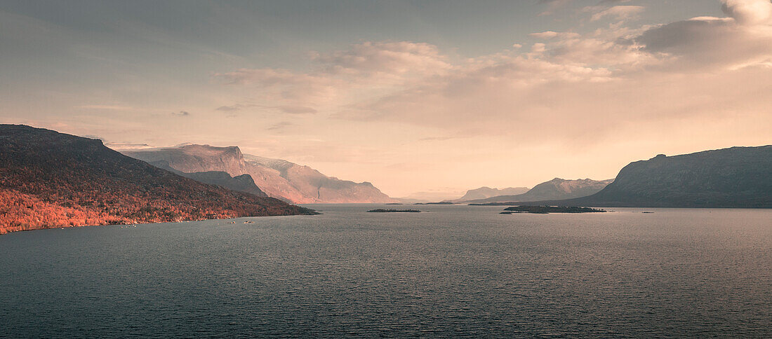 Landschaft mit Bergen und See im Stora Sjöfallet Nationalpark im Sonnenuntergang in Lappland in Schweden\n