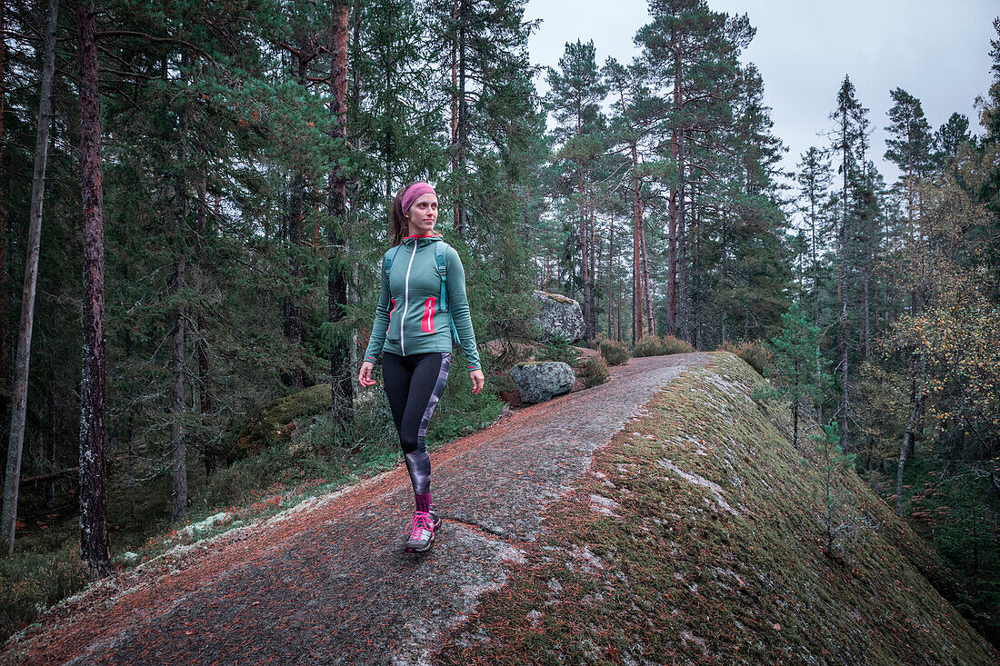 Woman hiking in the forest of Tiveden National Park in Sweden