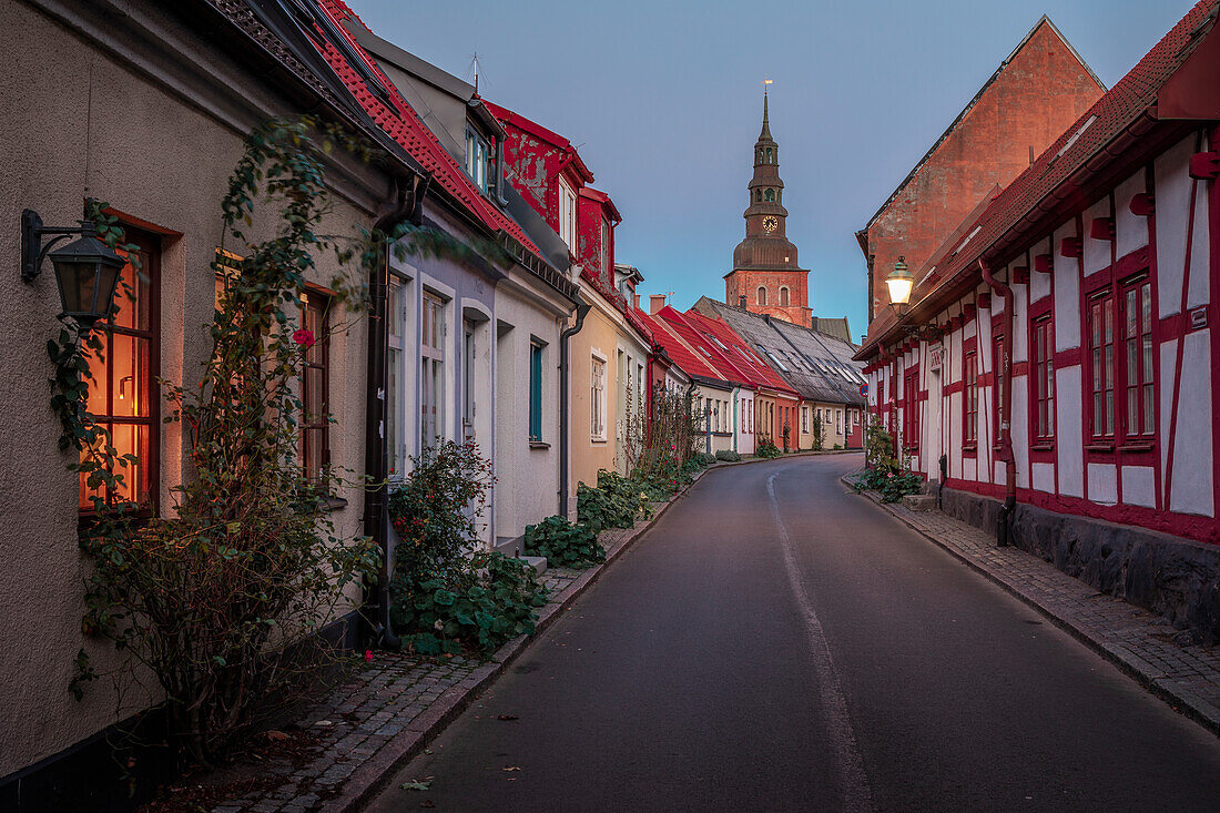 Straße mit Sankt Marien Kirche in Ystad in Schweden im Sonnenuntergang\n