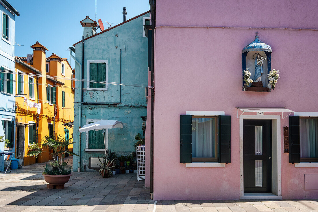 Madonna-Schrein mit Blumenschmuck an bunter Hausfassade, Fischerinsel Burano, Venedig, Venetien, Italien, Europa