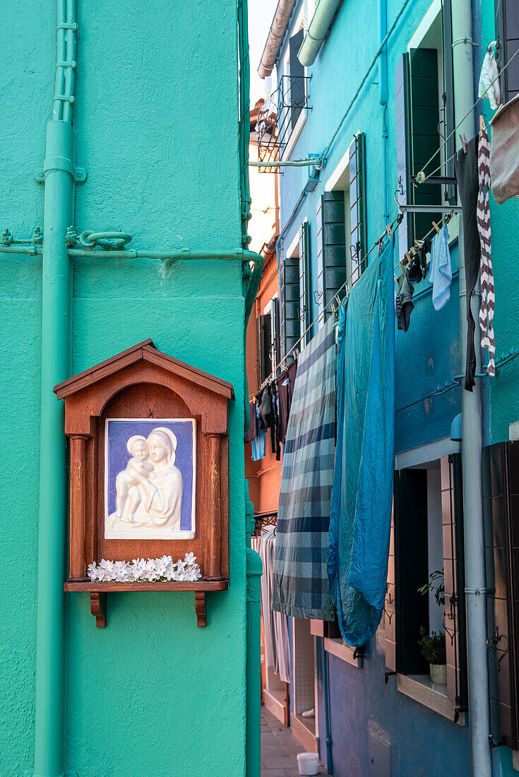 Madonna-Schrein mit Blumenschmuck an bunter Hausfassade, Fischerinsel Burano, Venedig, Venetien, Italien, Europa