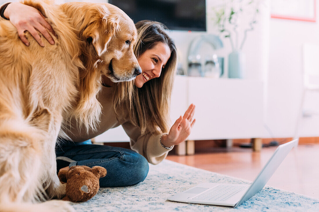 Italien, junge Frau mit Hund, die Laptop betrachtet