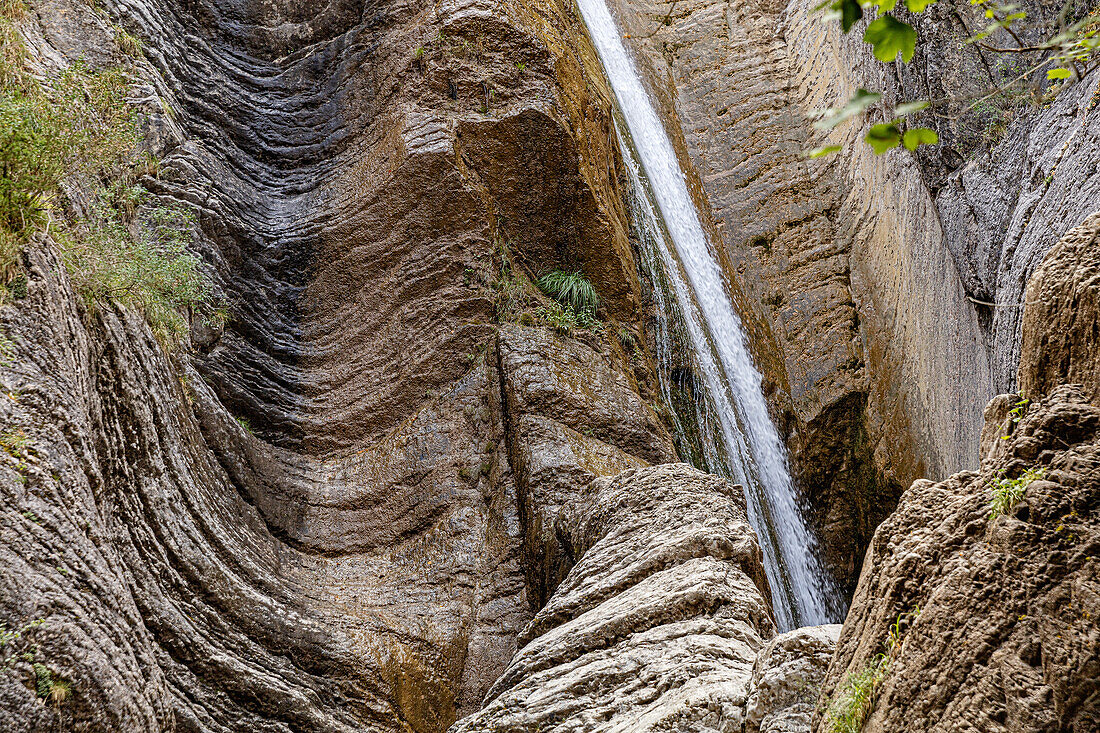 Frankreich, Alpes-de-Haute-Provence, Niedrigwinkelansicht des Wasserfalls auf erodiertem Felsen