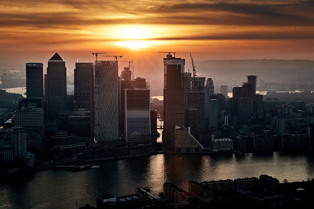 UK, London, Canary Wharf skyscrapers and river Thames at sunset