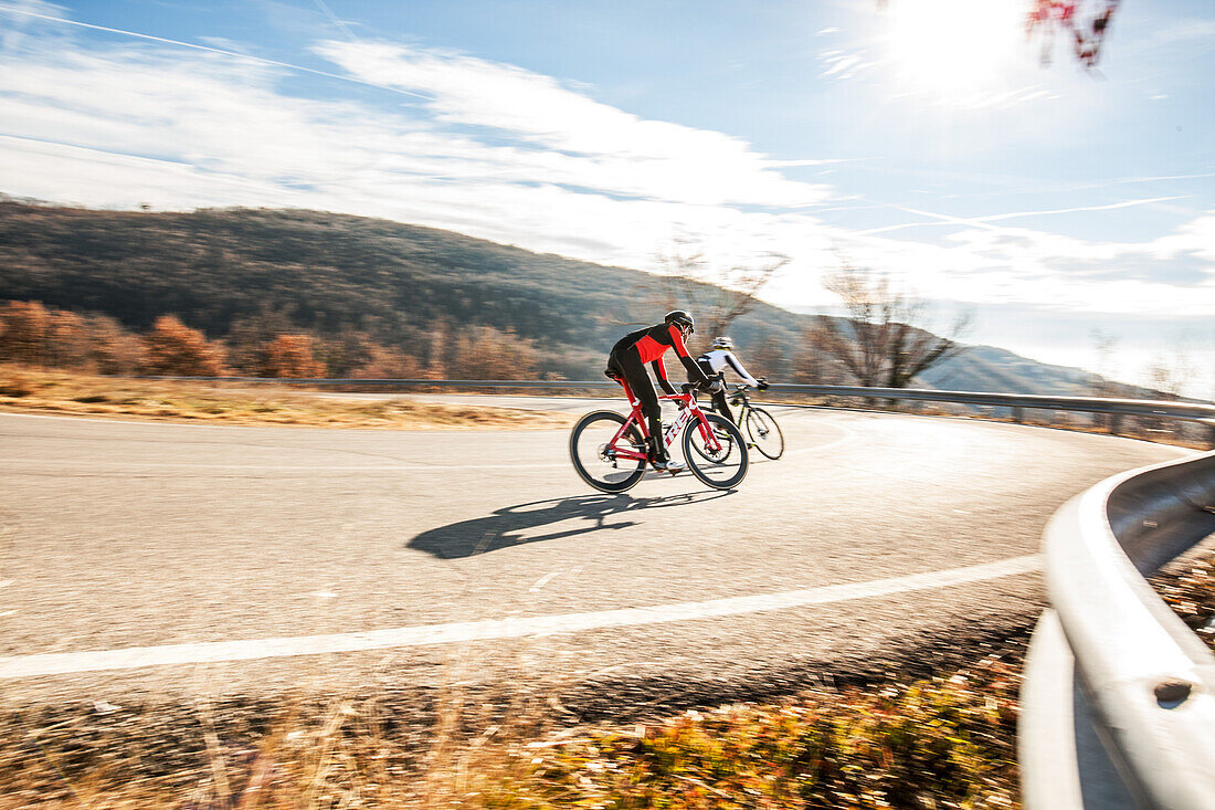 Two racing cyclists on pass road in Valpolicella,