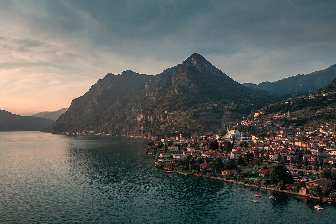 Iseosee mit Dorf Marone und Bergen im Sonnenuntergang, von oben, Italien