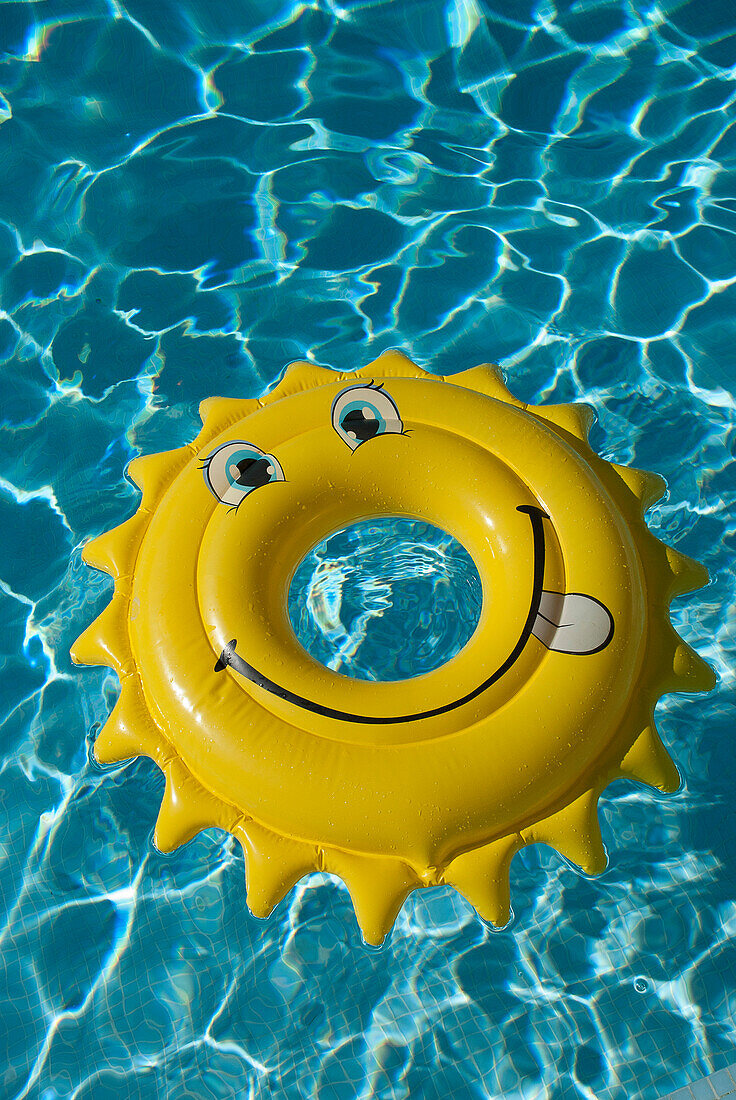 An buoy shaped line a sun, floats in a swimming pool, south of france