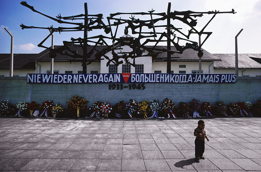 Child standing in front of a memorial, Dachau concentration camp, Dachau, Germany