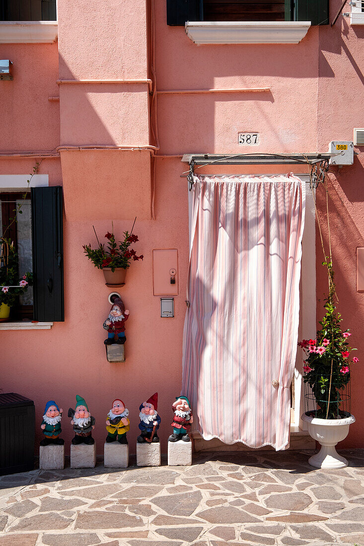 Blick auf eine bunte Fassade mit sechs Zwergen in Burano, Lagune von Venedig, Venetien, Italien, Europa