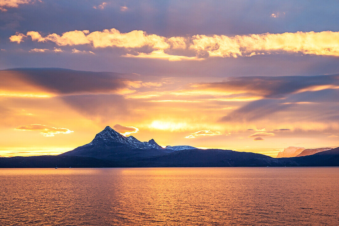 Morgenliche Sonneneinstrahlung einer Bergkette nördlich von Harstad, Hurtigrute, Nordland, Norwegen, Europa
