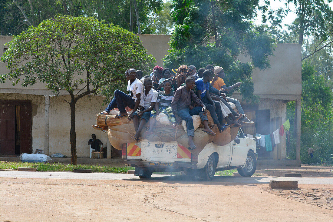 Uganda; Zentraluganda im Distrikt Nakasongola; an der Straße von Kampala nach Masindi bei Nakitoma; voll beladenes Pickup-Buschtaxi; Fahrgäste sitzen hinten auf dem Gepäck