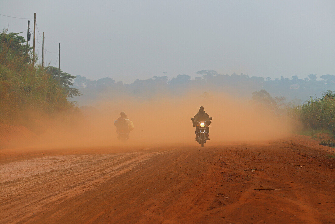 Uganda; Western Region; zwischen Hoima und Fort Portal; Motorradfahrer auf der staubigen Straße