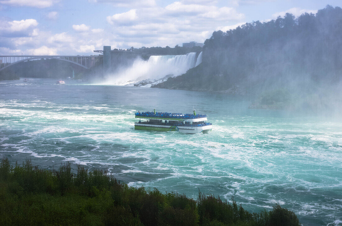 A Maid of the Mist boat in the Niagara river, as seen from Niagara Falls, Canada