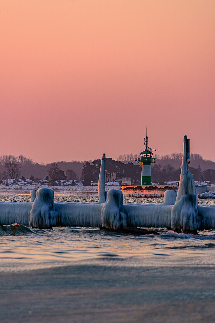 Icy old wooden pier on the beach, in the background pier light (lighthouse), Travemünde, Bay of Lübeck, Schleswig Holstein, Germany
