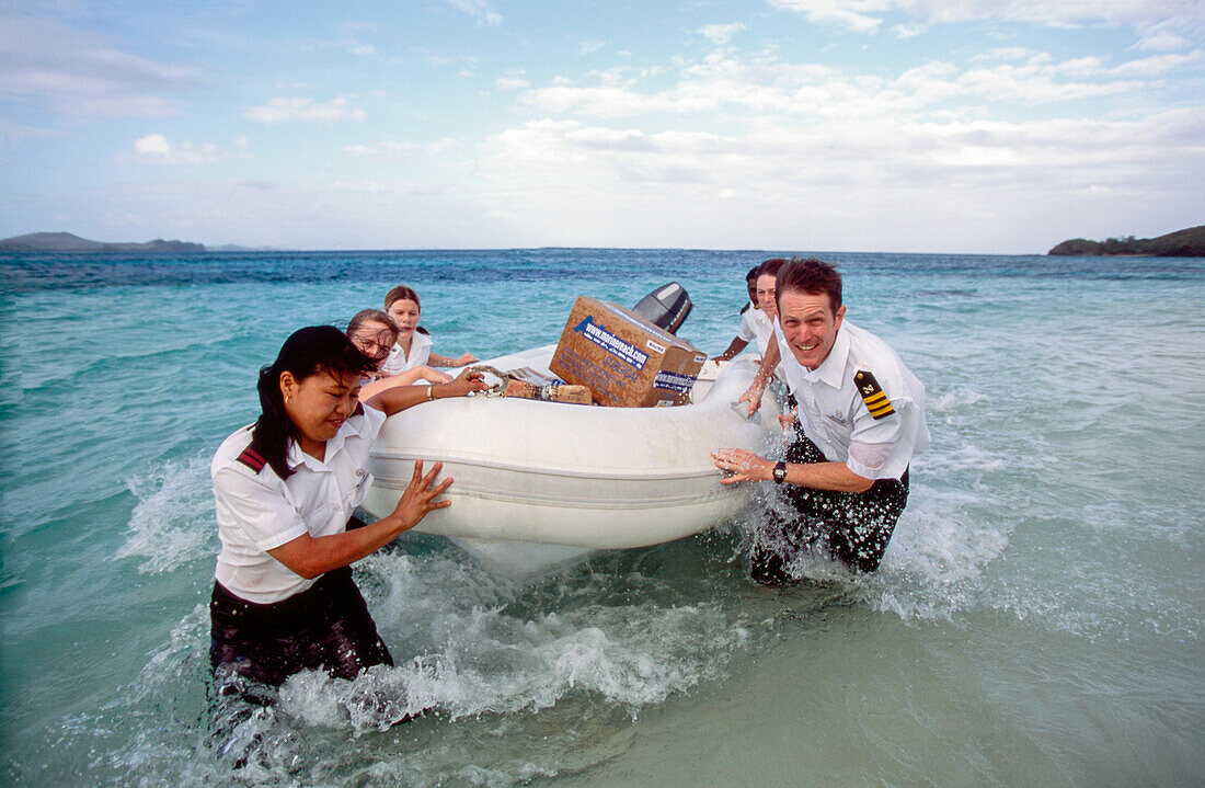 Medical team and volunteers landing on tropical Island with inflatable dingy for mercy outreach mission