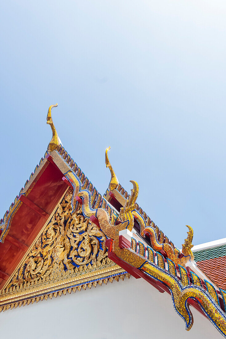 Aufwändige Dachspitze des buddhistischen Tempels gegen blauen Himmel in Bangkok, Thailand