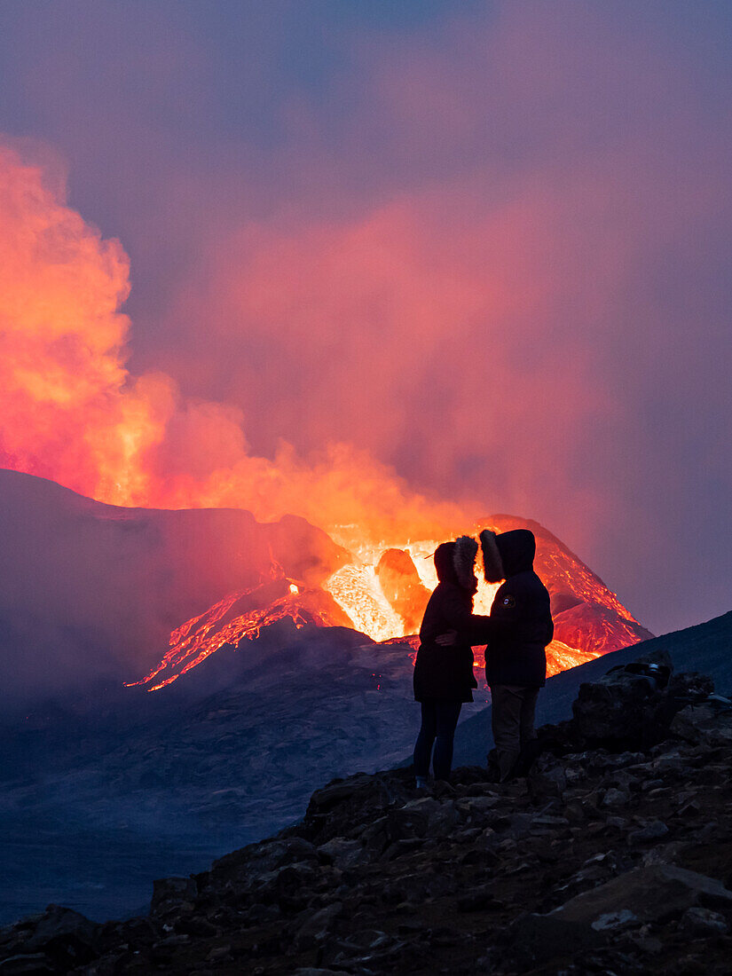 Couple enjoys eruption of Fagradalsfjall Volcano from Observation Hill, Iceland