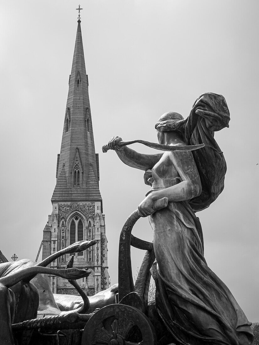 Statue in fountain across from steeple