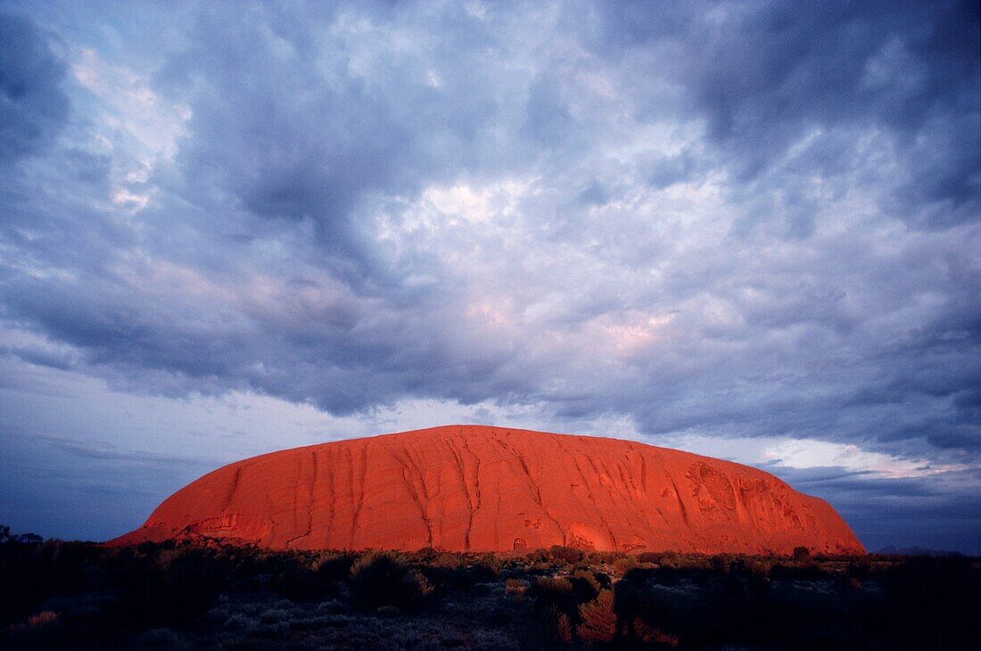 Wolken über Felsformationen aus Sandstein, Uluru, Uluru-Kata Tjuta National Park, Northern Territory, Australien