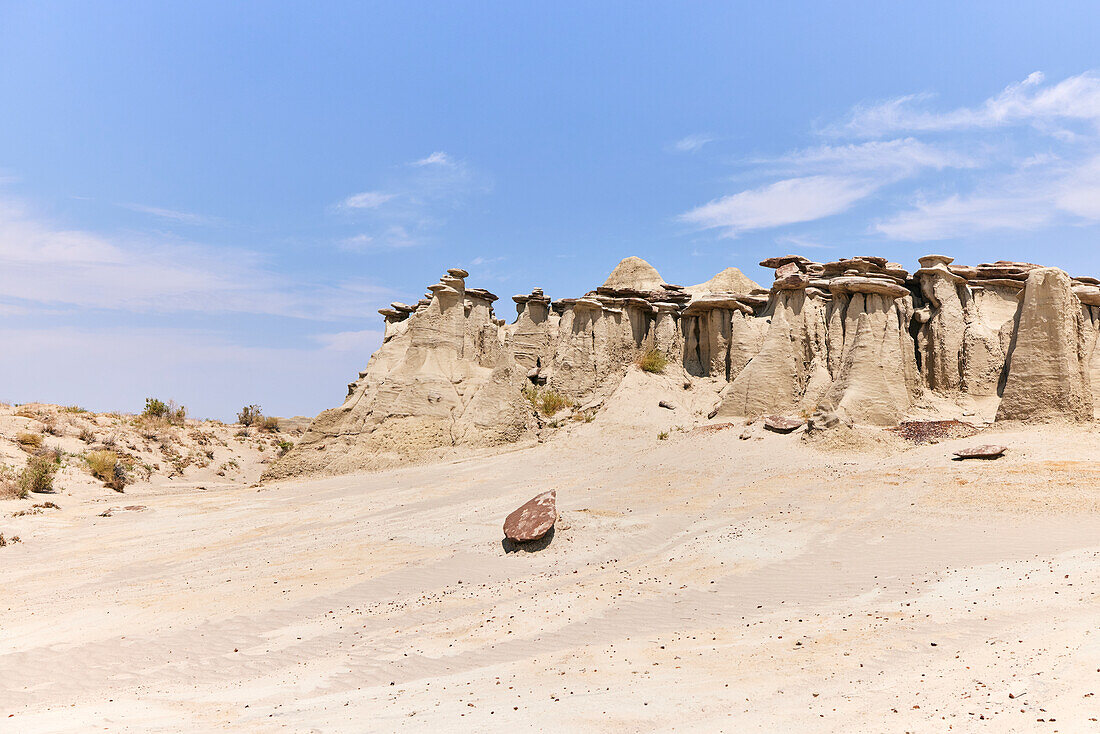 Sandstone hoodoos and a clear blue sky at Ah-shi-sle-pah Wilderness Study Area in New Mexico. Area is located in northwestern New Mexico and is a badland area of rolling water-carved clay hills. It is a landscape of sandstone cap rocks and scenic olive-colored hills. Water in this area is scarce and there are no trails; however, the area is scenic and contains soft colors rarely seen elsewhere