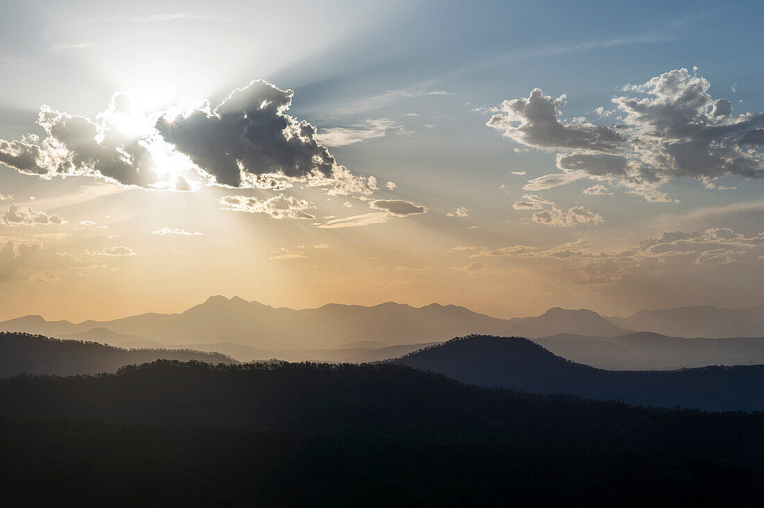 Am späten Nachmittag scheinen die Sonnenstrahlen durch die Wolken über der Main Divide Mountain Range vom Lamington National Park