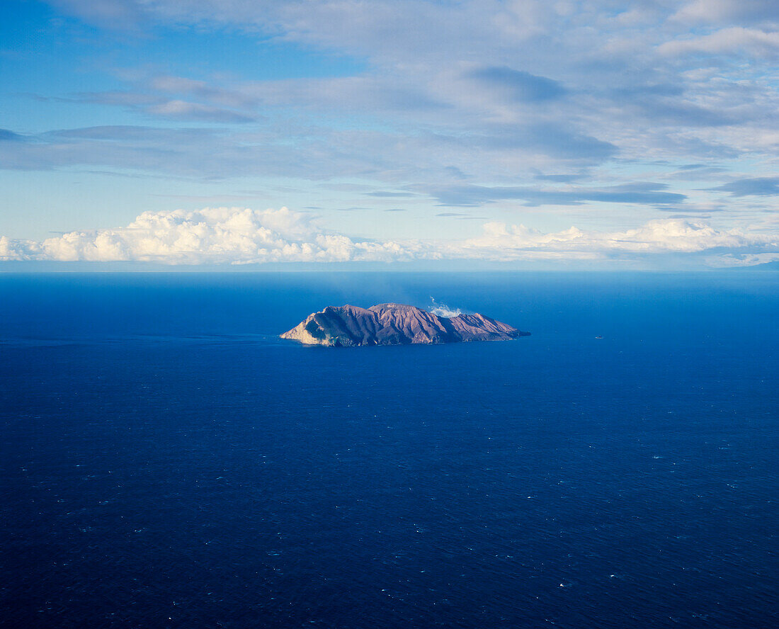 Luftaufnahme von White Island - Vulkaninsel umgeben von blauem Meer und Wolken