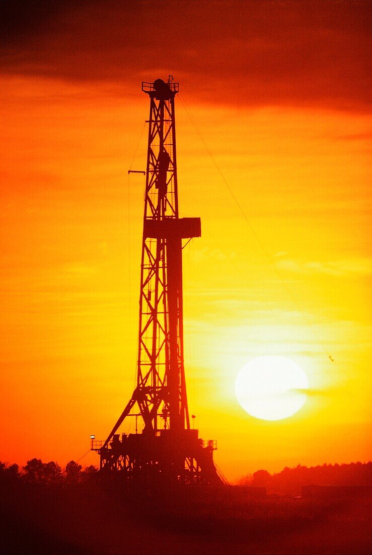 Silhouette of an oil drilling rig at sunset, Texas, USA