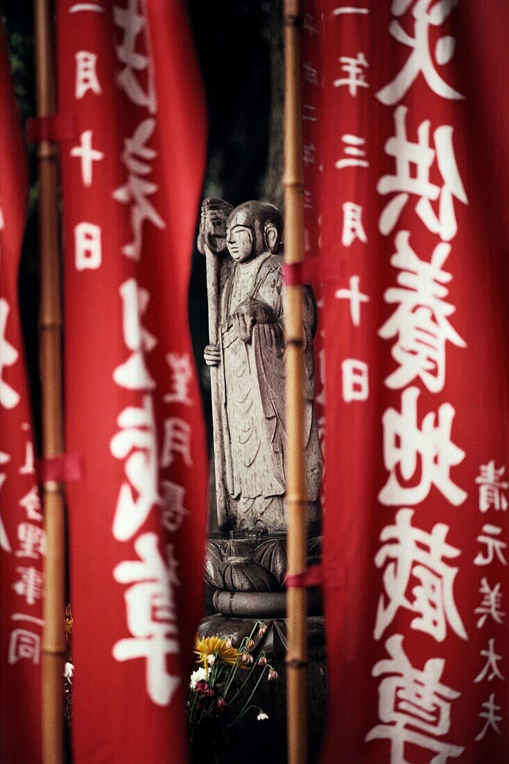 Buddha statue seen through banners, Tokyo, Japan