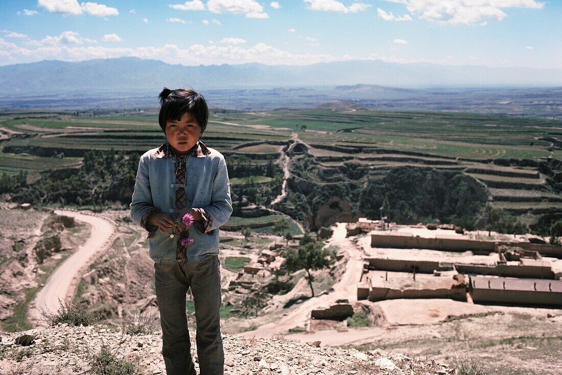Chinesisches Mädchen, das auf einem Hügel, China steht