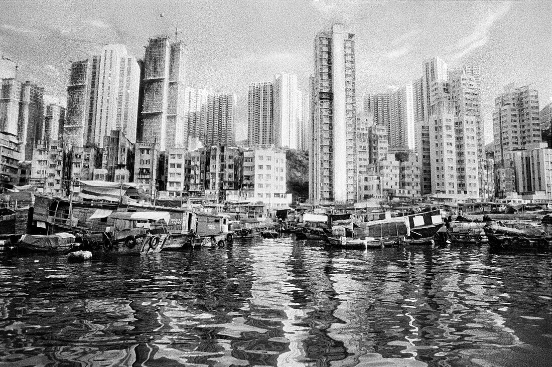 China, Hong Kong, Aberdeen Harbor, Chinese Junks docked on waterfront in front of Hong Kong residences