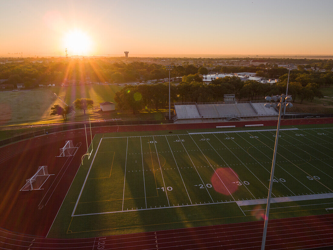 Luftaufnahme einer Highschool-Laufbahn und eines Fußballplatzes in Texas bei Sonnenaufgang