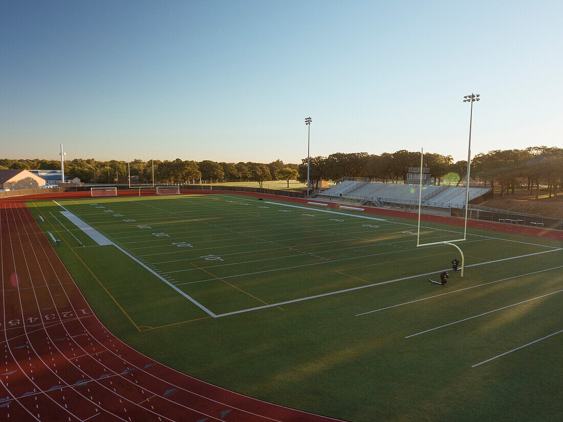 Aerial shot of a high school track and football field in Texas at sunrise