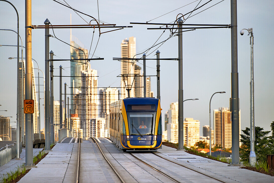 Tram travelling on lines and Surfers Paradise city in the background