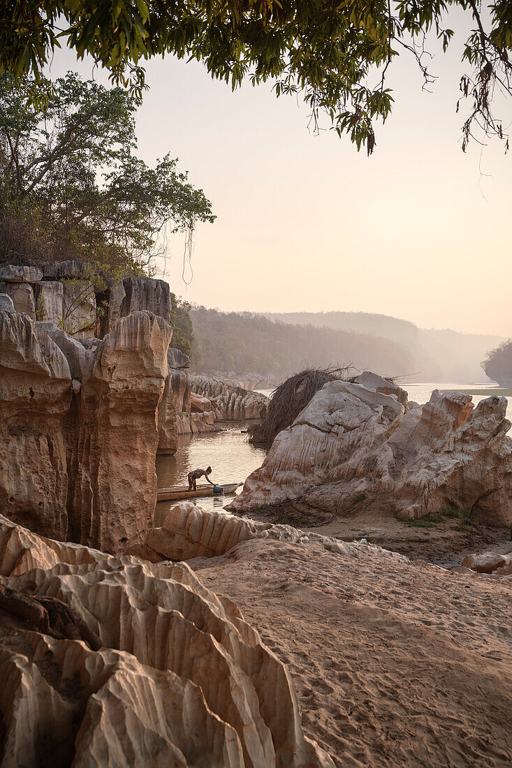 Frau in Boot holt Wasser aus Fluss Manambolo, Nationalpark Tsingy de Bemaraha, Bekopaka, Madagaskar, Provinz Mahajanga, Afrika, UNESCO Weltnaturerbe